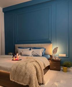a blue bedroom with a bed with candles on it at Couple friendly spacious 1BHK in Indore