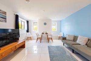 a living room with a couch and a tv at New 3 Bedroom Flat Close to Station in Chepstow