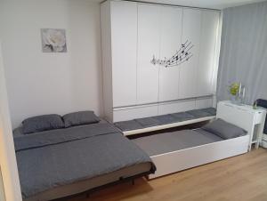 a bedroom with two beds and a white wall at Apartment S&S Tomislavgrad in Tomislavgrad