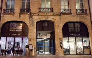 una fachada de un edificio con tres frentes de tienda en L'Empire Paris - Louvre, en París