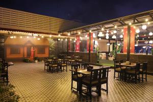 a restaurant with tables and chairs and lights at The Arcadia Coimbatore Airport in Coimbatore