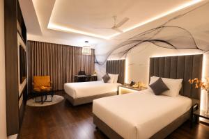 a hotel room with two beds and a chair at The Arcadia Coimbatore Airport in Coimbatore +96 photos