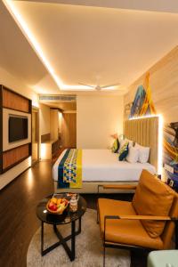 a hotel room with a bed and a table at The Arcadia Coimbatore Airport in Coimbatore
