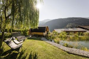 Eine Bank, die im Gras neben einem See steht in der Unterkunft Bachmannhof in Feldthurns