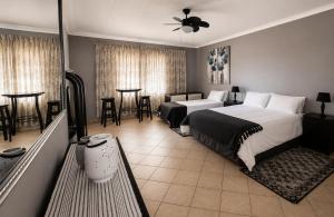 a bedroom with two beds and a table and chairs at Anna Boeremeisie Guesthouse in Benoni