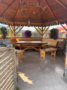 a large wooden table and benches in a pavilion at Casa Petrişor in Corbi