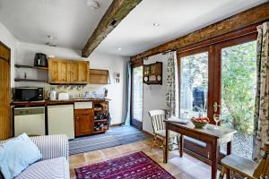 a living room with a table and a kitchen at Finest Retreats - The Little Barn in Great Somerford