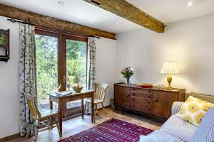 a living room with a table and a desk and a window at Finest Retreats - The Little Barn in Great Somerford
