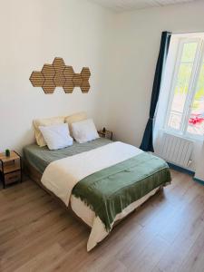 a bedroom with a bed and a large window at Appart cosy avec billard, à Bort in Bort-les-Orgues