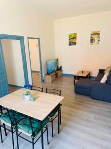 a living room with a table and a couch at Appart cosy avec billard, à Bort in Bort-les-Orgues +23 photos