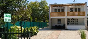a house with a green fence and a sign in front of it at Karolin Apartman in Bükfürdő