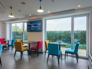 a dining room with colorful chairs and a table at Ibis Styles Bucharest Airport in Otopeni