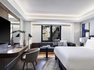 a hotel room with a bed and a desk and a couch at Athens Capital Center Hotel - MGallery Collection in Athens