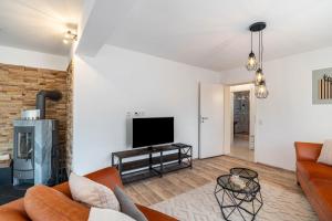a living room with a couch and a tv at Zwischen Schwarzwald und Rhein in Sinzheim