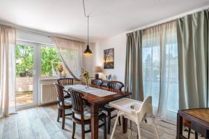 a dining room with a table and chairs and windows at Zwischen Schwarzwald und Rhein in Sinzheim