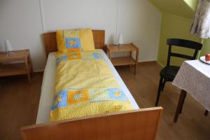 a small bedroom with a bed and a table and chairs at Hotel Restaurant Koi-Gartenteich in Hausernmoos
