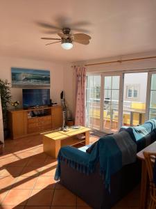 a living room with a couch and a tv at T2 Duplex apartment in Cabanas de Tavira