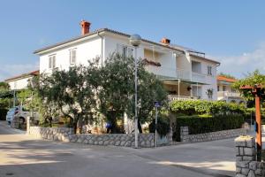 a white house with a tree in front of it at Rooms with a parking space Krk - 5371 in Krk