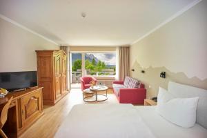 a hotel room with a bed and a tv at Alpenhof Grainau in Grainau