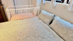 ein Kinderbett in einem Zimmer mit Bett und Kissen in der Unterkunft Waldbach Stube in Gernsbach