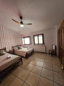 a bedroom with two beds and a ceiling fan at Casa Ioar in Los Arcos