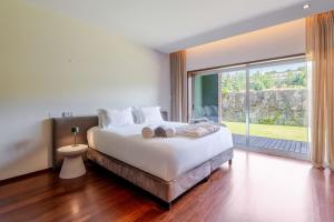 a bedroom with a large bed and a large window at Stars View by Portugal Active in Fafe