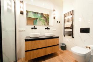 a bathroom with two sinks and a toilet at Apartament Kutno - Sami Swoi in Kutno