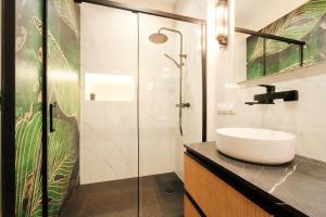 a bathroom with a sink and a glass shower at Apartament Kutno - Sami Swoi in Kutno