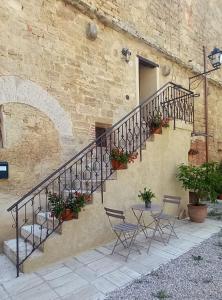 a staircase with chairs and a table in front of a building at Dimora San Francesco in Asciano