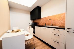 a kitchen with white cabinets and a sink at Apartament Kutno - Sami Swoi in Kutno