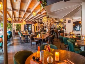 a restaurant with wooden tables and green chairs at Pet-Friendly Chalet Near Efteling in Kaatsheuvel