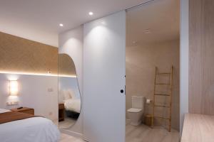 a bedroom with a bed and a bathroom with a mirror at Kamiñone Landetxea in Beasain +16 photos