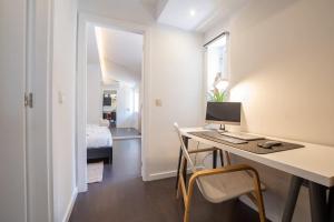 a room with a desk with a computer and a bed at PortugalActive Beach Flat in Viana do Castelo