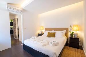 a bedroom with a large white bed with towels on it at PortugalActive Beach Flat in Viana do Castelo