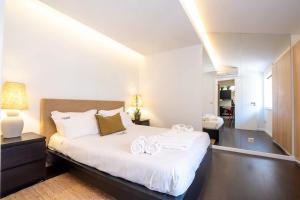 a bedroom with a large white bed with towels on it at PortugalActive Beach Flat in Viana do Castelo +21 photos
