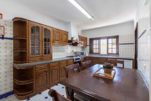 a kitchen with wooden cabinets and a wooden table at Villa Brisa do Mar by Algarve Holidays in Galé +23 photos