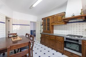 a kitchen with wooden cabinets and a table and a dining room at Villa Brisa do Mar by Algarve Holidays in Galé