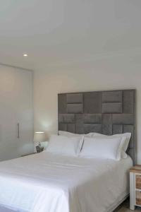 a bedroom with a large white bed with a headboard at Vida Tranquila Guest House in Welgelegen