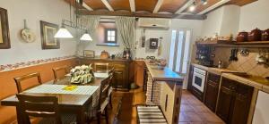 a kitchen with a table and chairs and a table and a counter at Casa Turística Los Girasoles 