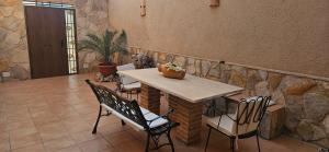 a table and chairs in a room with a stone wall at Casa Turística Los Girasoles  +9 photos