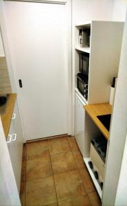 a small kitchen with a white refrigerator and a tile floor at Apartmán Kácov in Kácov