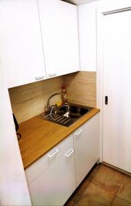 a kitchen with a sink and white cabinets at Apartmán Kácov in Kácov +4 photos