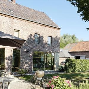 a brick house with large windows and a patio at De Watermolen in Ninove