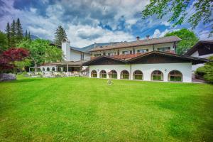 a large house with a green lawn in front of it at Alpenhof Grainau in Grainau