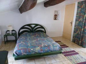 a bedroom with a bed with a colorful quilt at Brimborion in Alba-la-Romaine