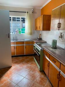 a kitchen with wooden cabinets and a stove top oven at The Place in Umtali