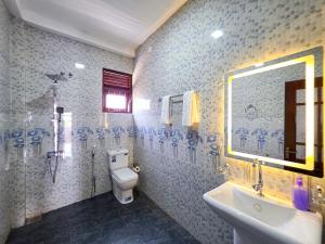 a bathroom with a toilet and a sink and a mirror at Dishan Green Retreat in Ambalangoda +32 photos