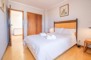 a bedroom with a large white bed with two towels on it at Ocean view Cabedelo Beach Duplex in Viana do Castelo