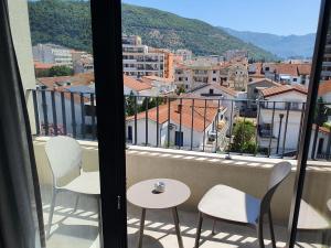 a balcony with chairs and a view of a city at Lucciola Boutique Rooms in Budva