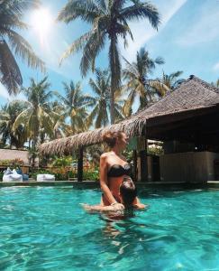 a man and woman in the swimming pool at a resort at Trawangan Oasis in Gili Trawangan